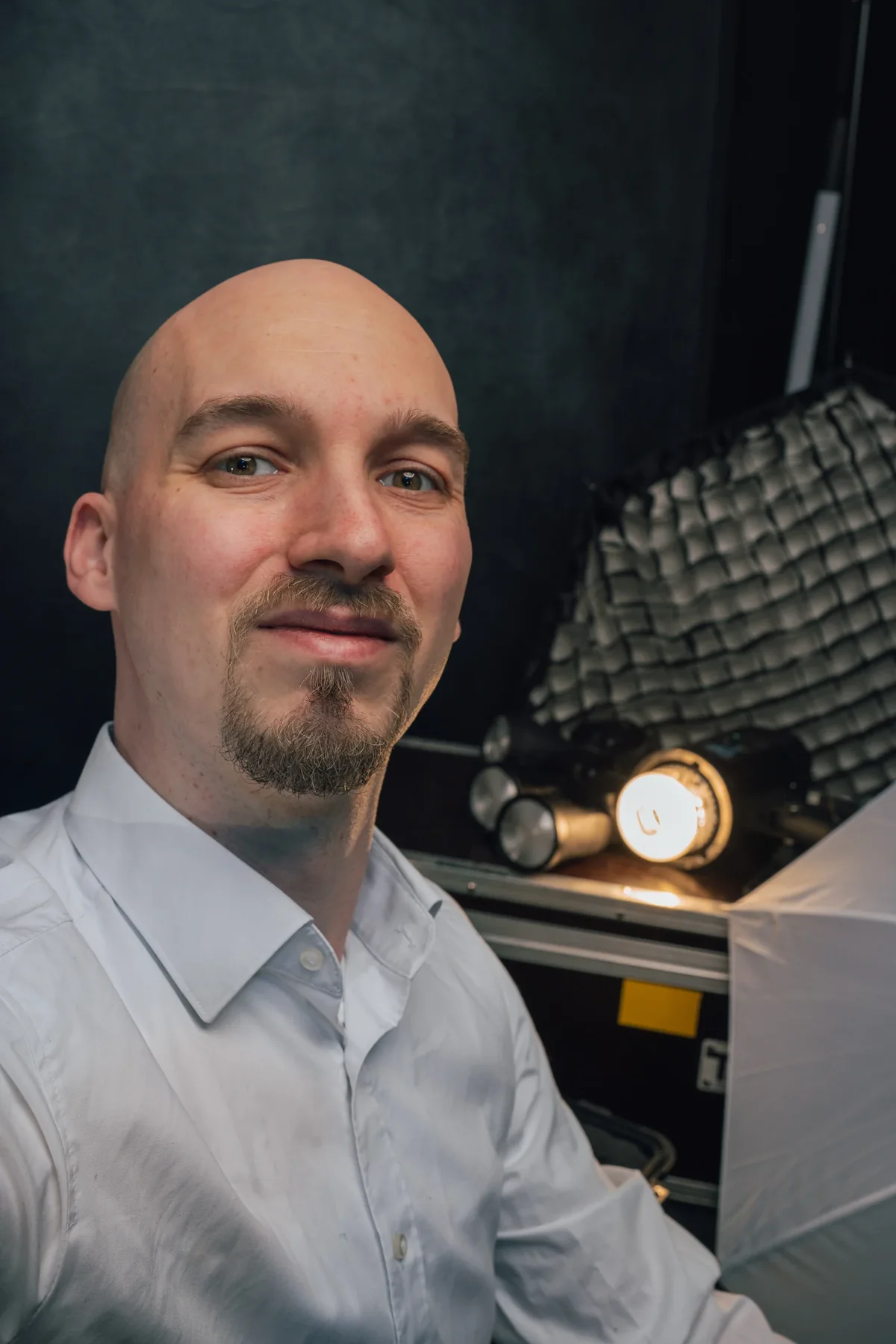 Mann im weißen Hemd vor dunklem Hintergrund, Softbox im Bild