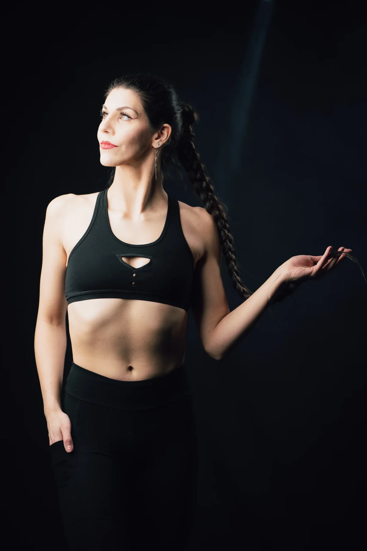 Model im Sporttop vor schwarzem Hintergrund